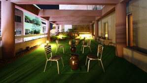 An indoor garden with artificial grass, seating, and decorative vases. - Daedong Hotel (Jeju City)