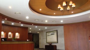 A lobby with a reception desk, a chandelier, recessed lighting, and a framed artwork on the wall. - Daedong Hotel (Jeju City)