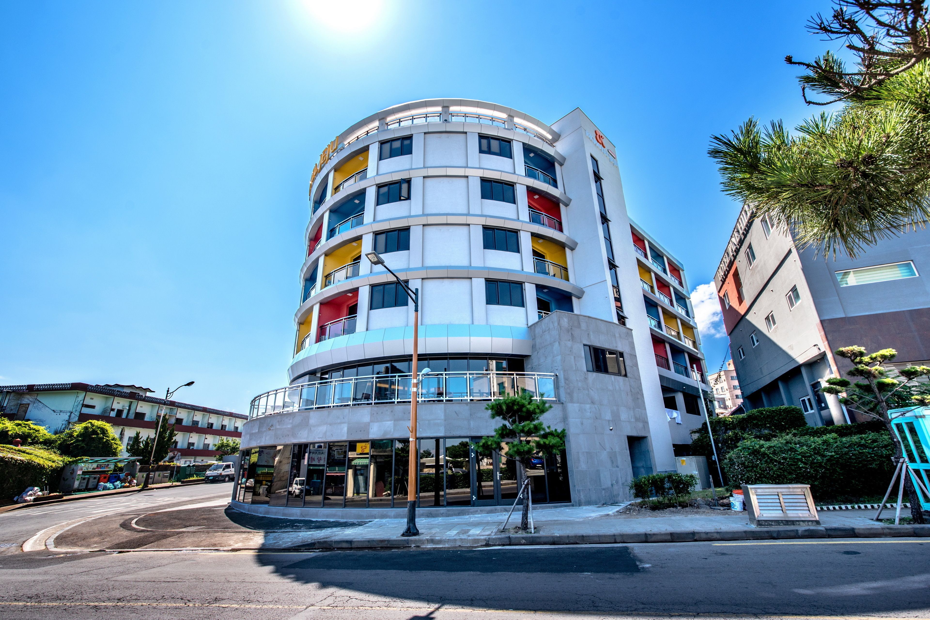 A multi-story hotel with a curved facade, multiple balconies, and a modern architectural design.