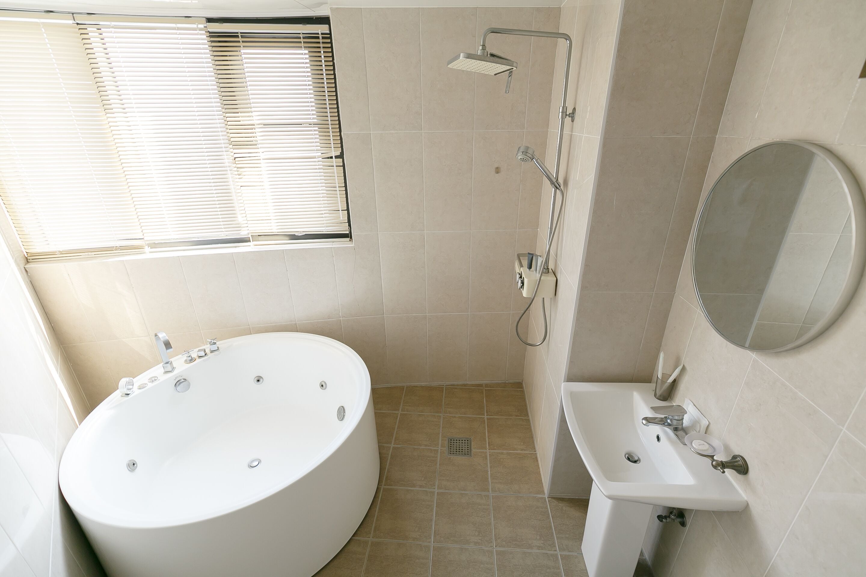 A modern bathroom with a freestanding bathtub, a shower, a sink, and a mirror.