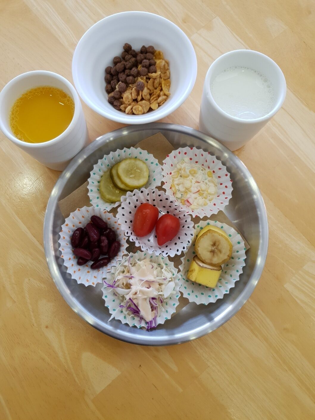A meal with various food items on a plate, accompanied by three small bowls containing different beverages.