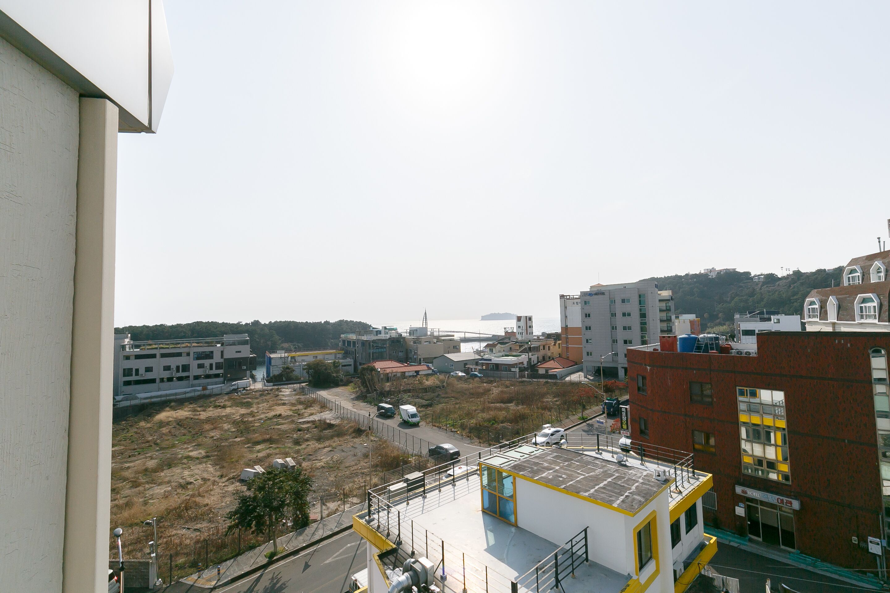 A view of a cityscape with buildings, a parking lot, and a distant bridge.