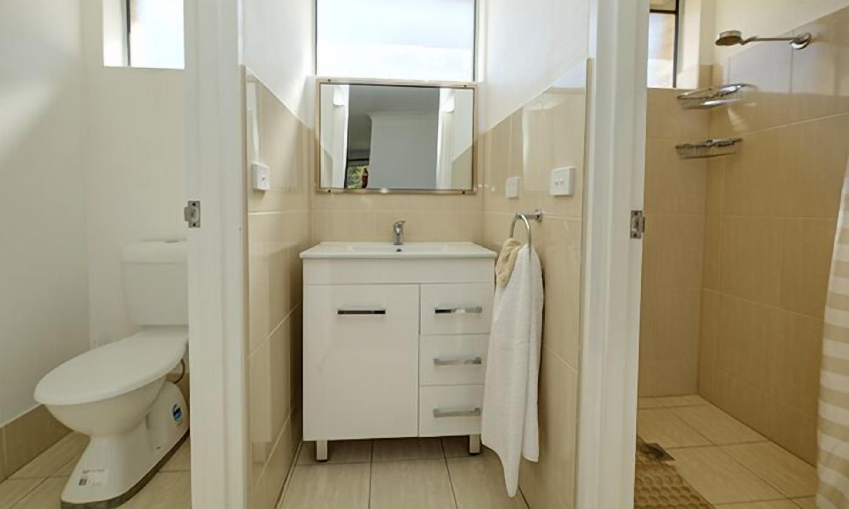 Un baño con inodoro, lavamanos y ducha.