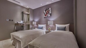 A hotel room with two beds, a desk, a mirror, and a painting on the wall. - Hotel B7 Journey (TAIPEI)