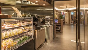 A modern café interior with a menu board, coffee machines, and a display case with pastries. - Beauty Hotels Taipei Hotel B7 Journey (Taipei)