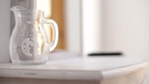 A clear glass pitcher with a moon design on a white surface. - Acuario Guest House (Oristano)