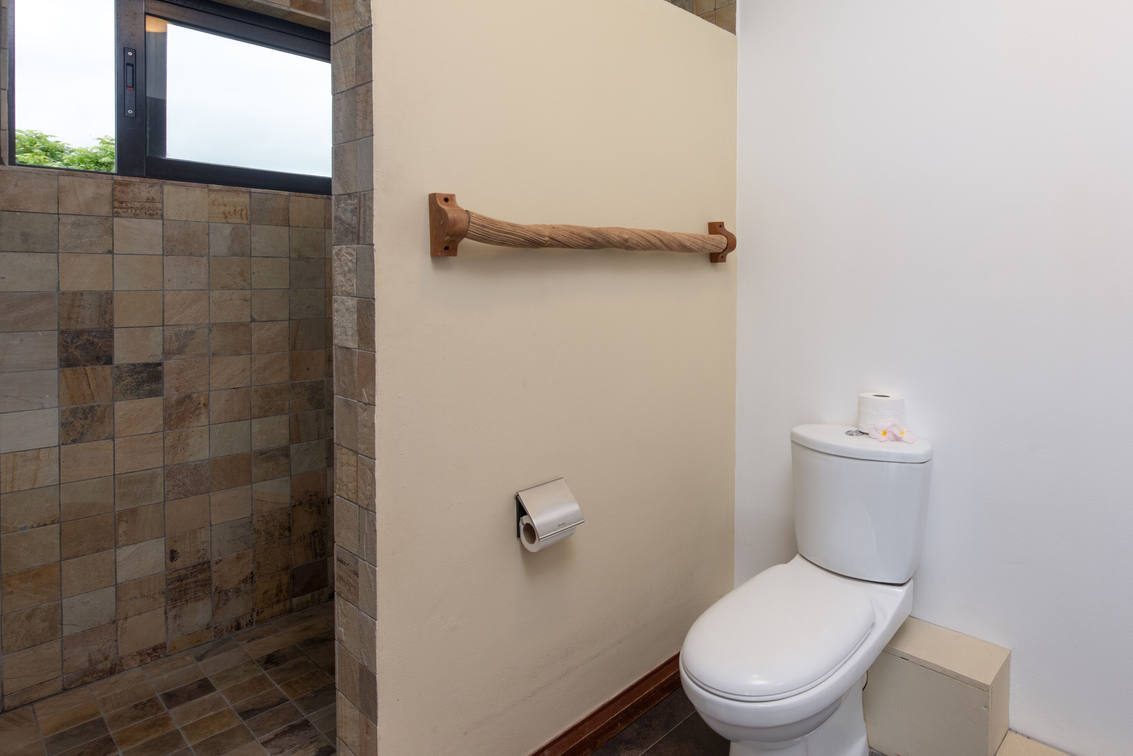 Ein Badezimmer mit Toilette, Handtuchhalter und Toilettenpapierhalter.