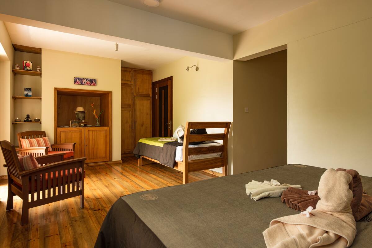 Ein Schlafzimmer mit Bett, Stuhl, Schreibtisch und Kleiderschrank.