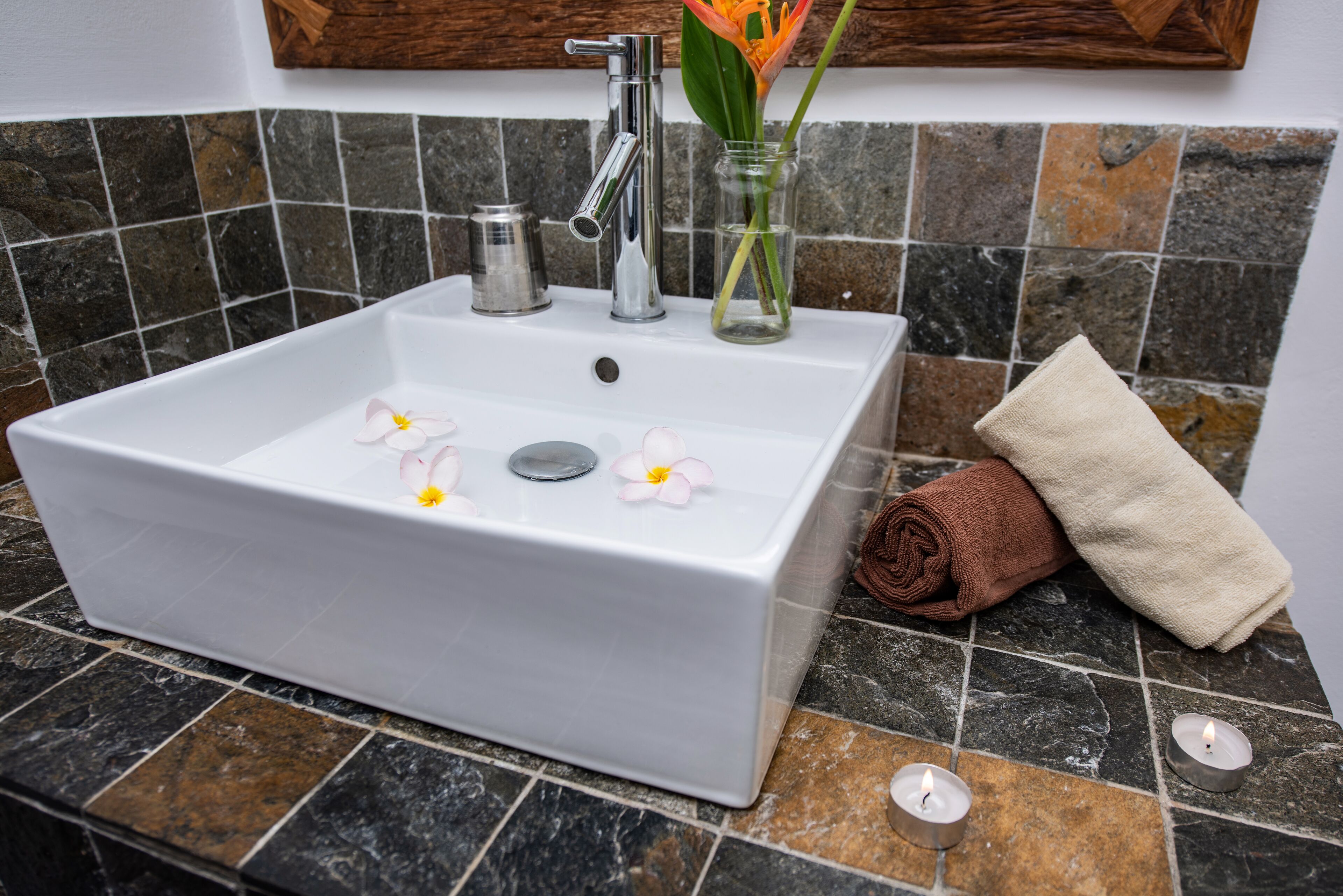 A bathroom with a white sink, a mirror, and a towel rack.