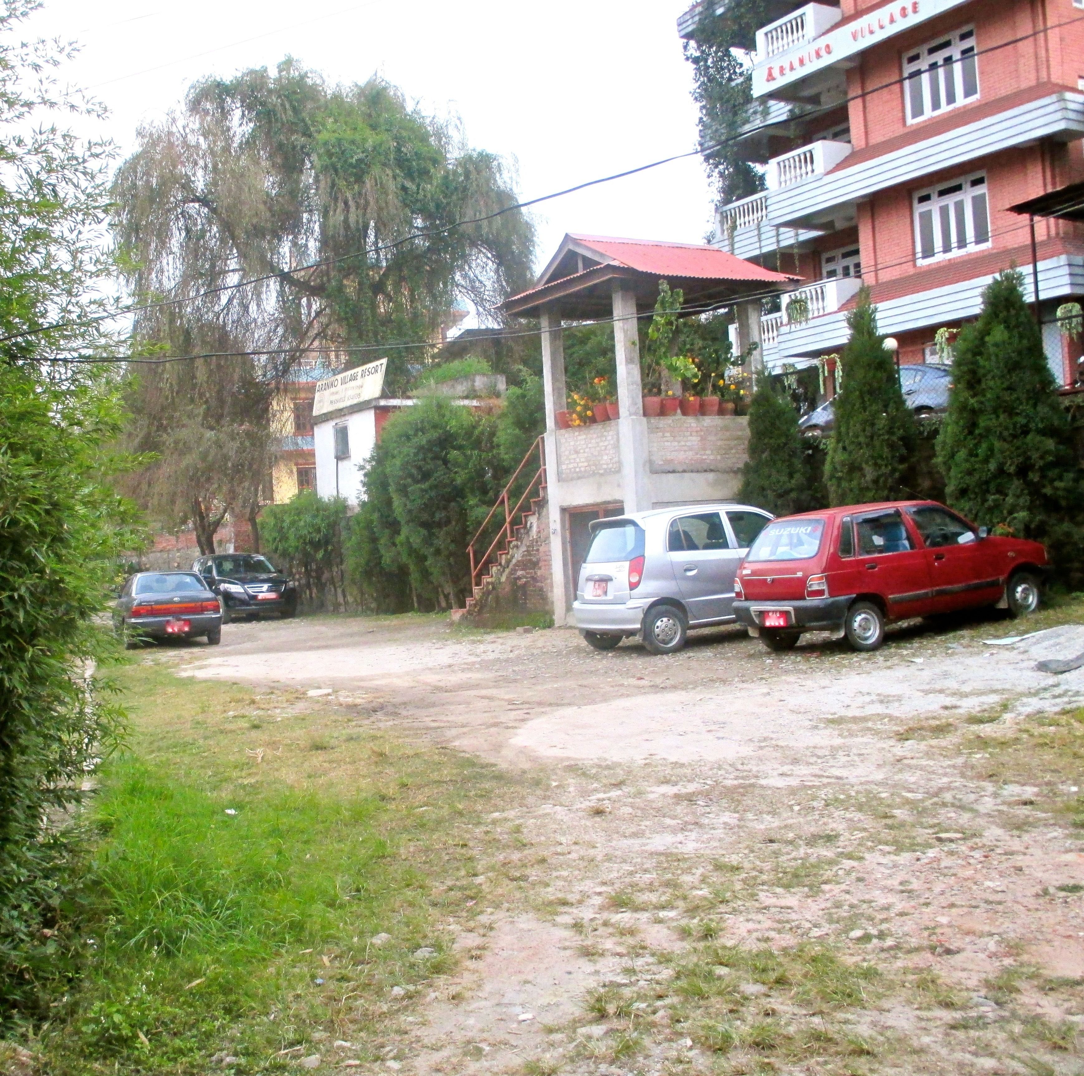 A residential area with a red car parked in front of a building labeled "Arancho Village Resort".