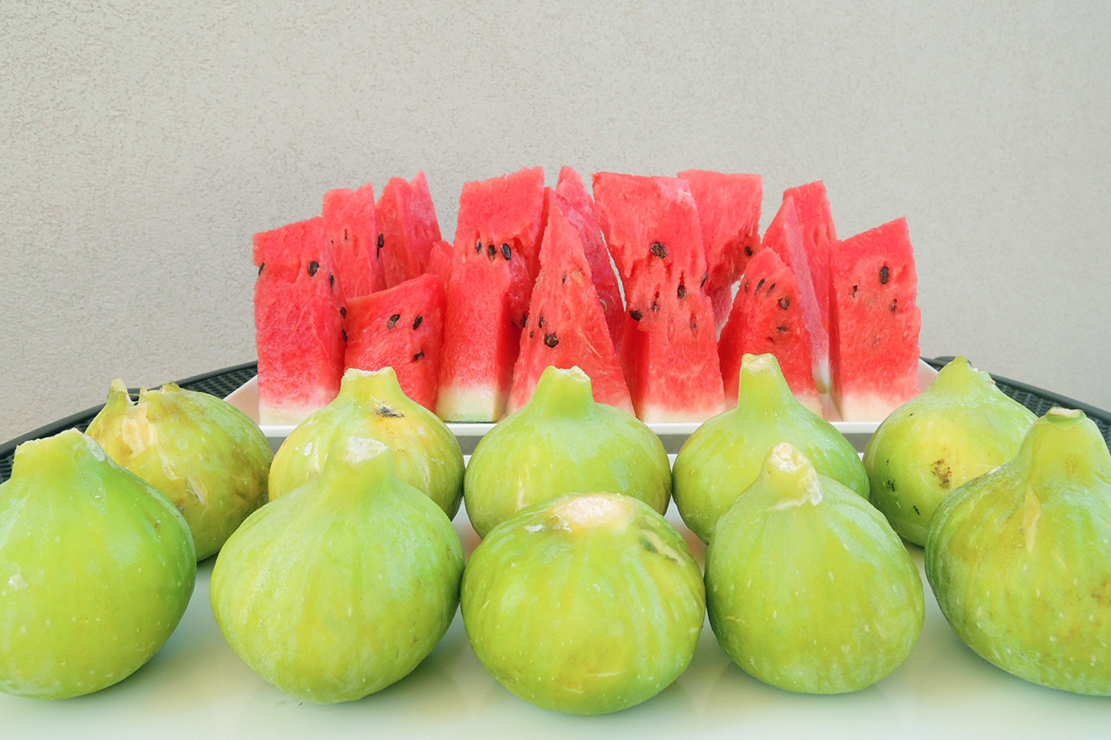 Ein Teller mit Wassermelone und grünen Früchten.