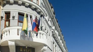 A hotel with a curved facade, multiple flags, and a prominent entrance.