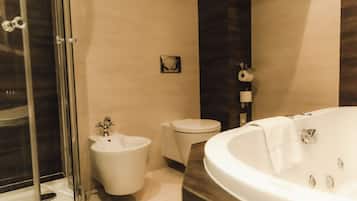 A modern bathroom with a freestanding bathtub, a bidet, and a toilet.