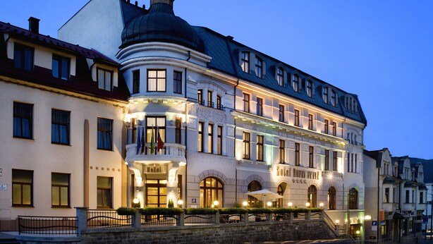A historic hotel with a prominent dome, a grand entrance, and a well-lit facade. - Hotel Dubna Skala (Zilina)
