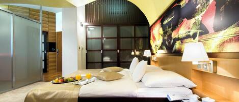 Una habitación de hotel con una cama, una mesita de noche y un cuadro grande en la pared.