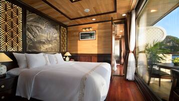 Un dormitorio amplio con una cama grande, techo de madera y vistas a un paisaje montañoso a través de un ventanal.