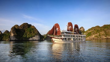 Experience panoramic views of the surrounding landscape from the spacious upper deck, featuring seating areas and large sails.