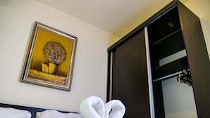 Een hotelkamer met een bed, een inlijsting foto aan de muur en een kledingkast.
