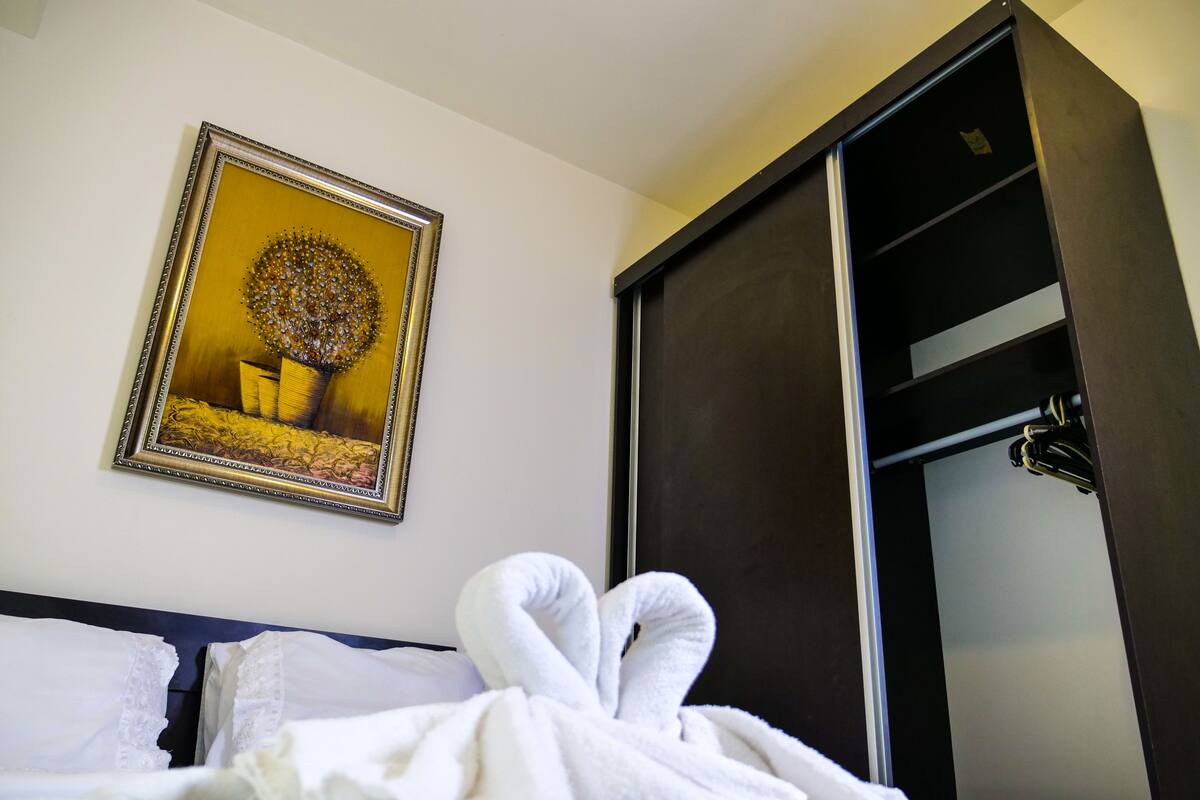 Ein Hotelzimmer mit einem Bett, einem gerahmten Bild an der Wand und einem Kleiderschrank.