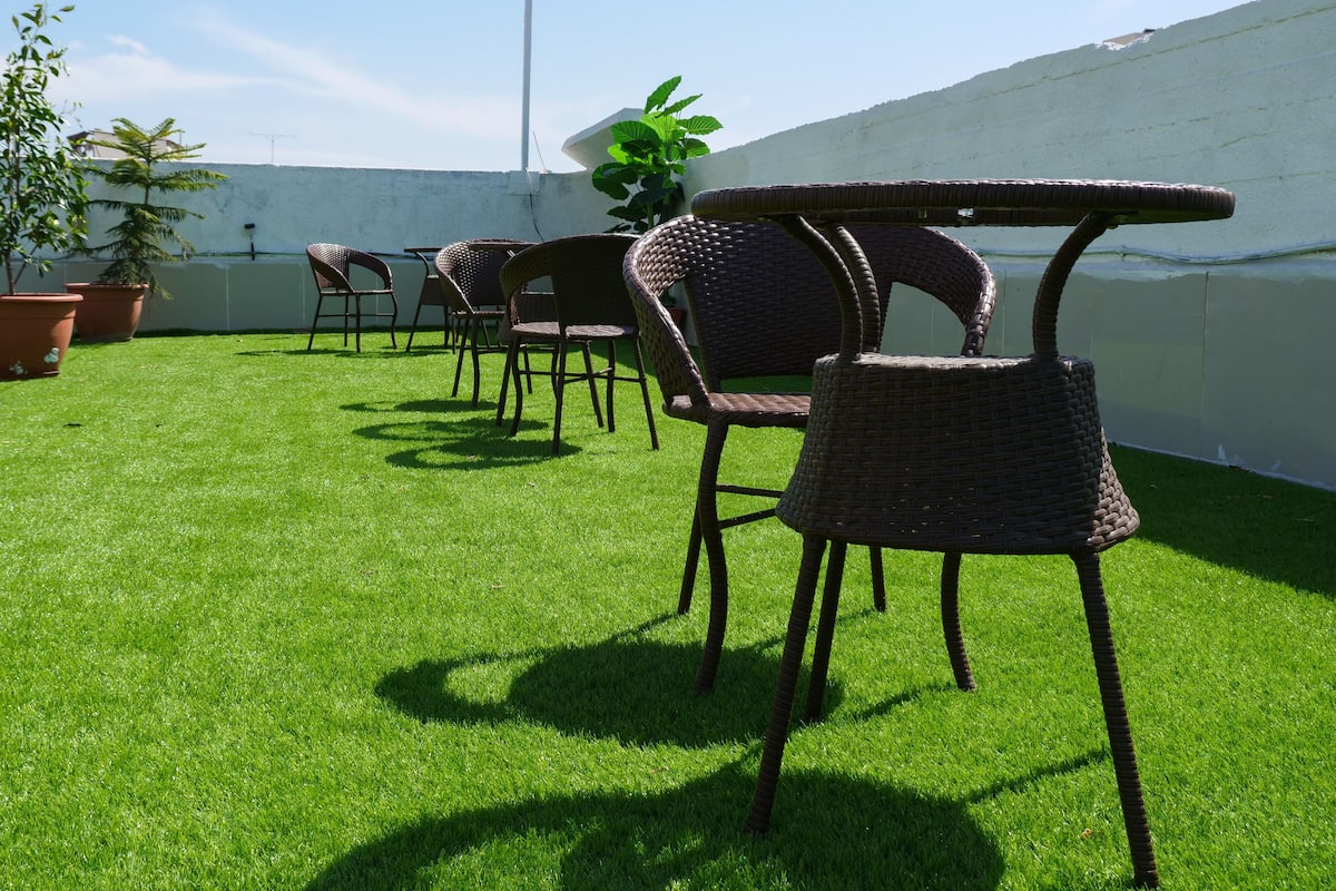 Eine Terrasse mit Gartenmöbeln und Blick auf ein Gewässer.