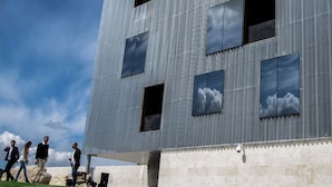Ein modernes Gebäude mit wellenförmiger Metallfassade, großen Fenstern und einem Flachdach.