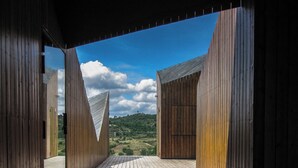 Eine Holzterrasse mit Blick auf eine hügelige Landschaft.