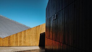 Ein Gebäude mit Holzfassade und einem Schild mit der Aufschrift 'BAR' auf der rechten Seite.