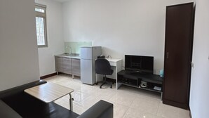 A compact living space with a kitchenette, a sofa, a TV, and a cabinet. - Taipei Happy Home (Taipei)