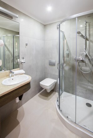 A modern bathroom with a glass-enclosed shower, a sink, and a toilet. - Hotel Szary Residence (Michalowice)