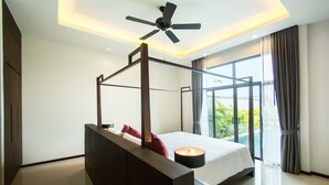 A modern bedroom with a four-poster bed, a ceiling fan, and a large window with curtains. - Saiyuan Estate by TropicLook (Rawai)