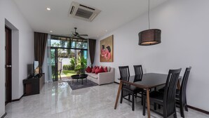 A modern dining area with a round table and chairs, a ceiling fan, and a large window with curtains. - Saiyuan Estate by TropicLook (Rawai)