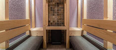 Una sauna con bancos de madera y piso de baldosas.
