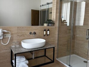 A modern bathroom with a large white sink, a glass shower enclosure, and a mirror above the sink. - Wellness Hotel Pivovar Monopol (Teplice)