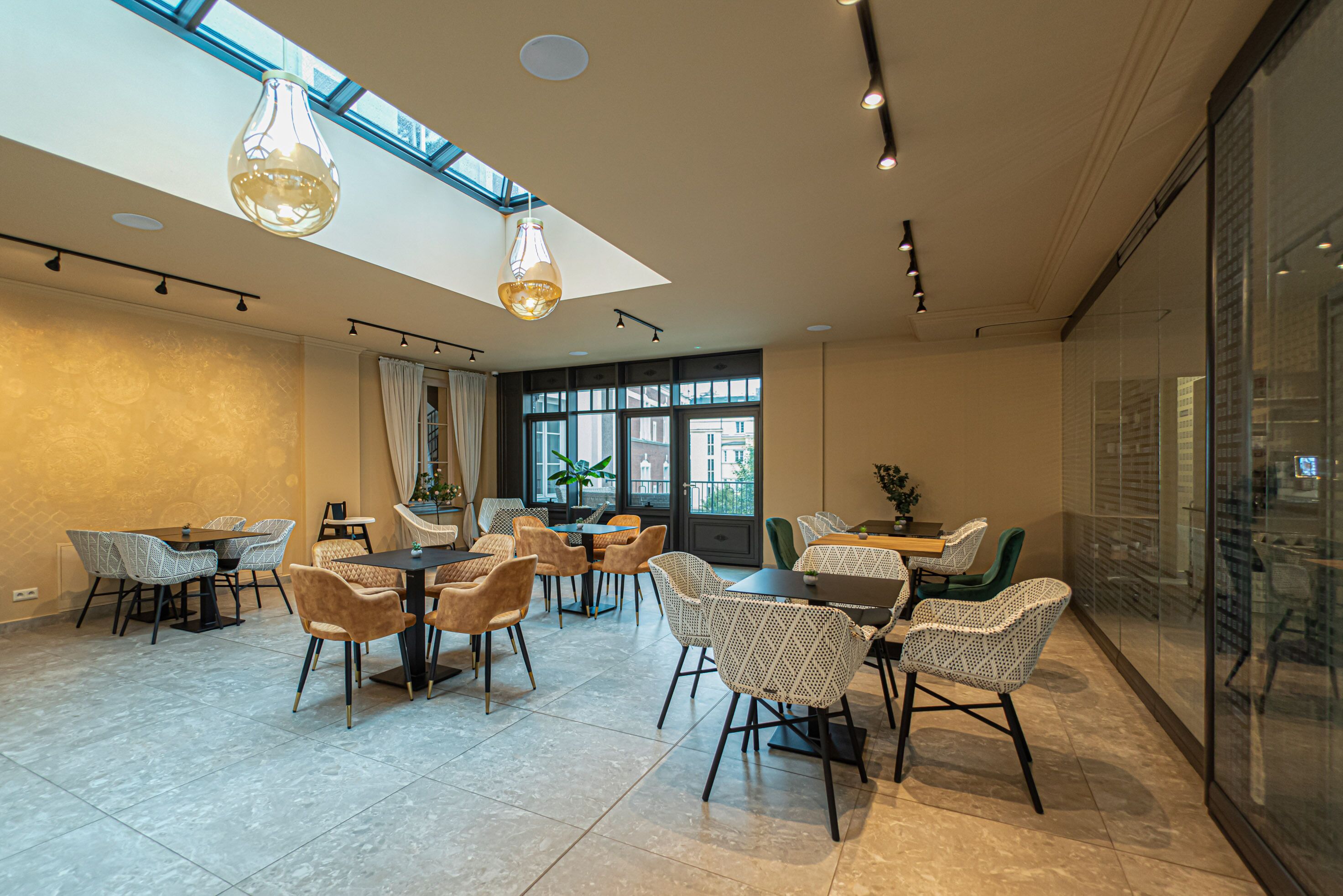 Un espace de restauration moderne, doté de hauts plafonds, de grandes fenêtres et de mobilier contemporain.