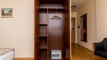 Un vestidor con puertas de madera, una barra para colgar ropa y una caja fuerte.