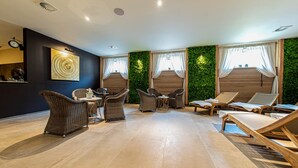 A spacious indoor area with wicker furniture, a wall-mounted clock, and a green wall.