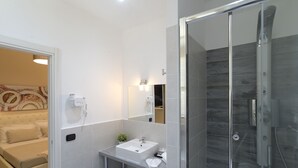A modern bathroom with a glass-enclosed shower, a white sink, and a small mirror. - Town House 57 (Rome)