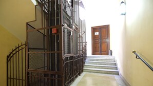 A staircase with metal railings and a wooden door at the top. - Town House 57 (Rome)