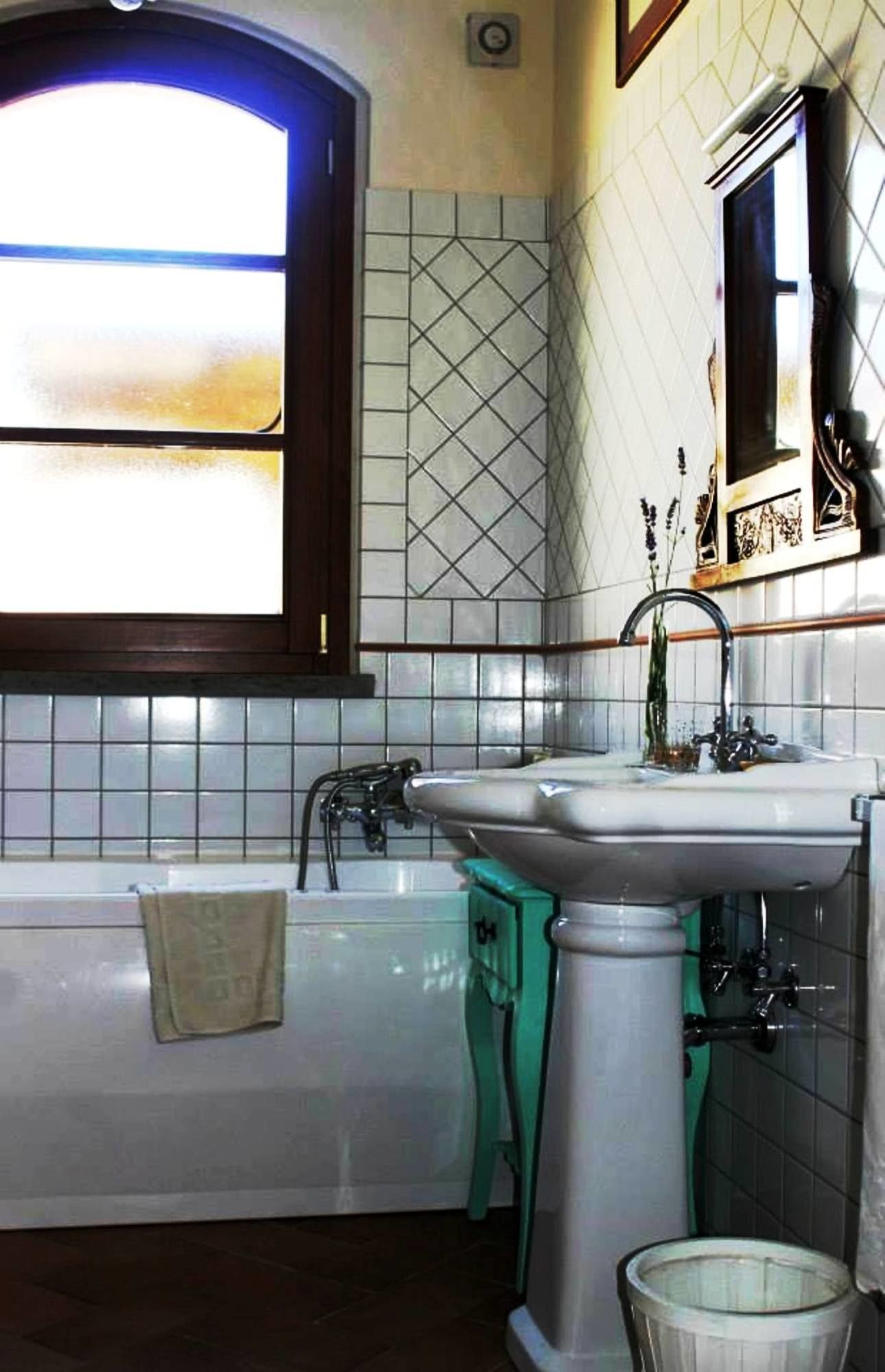 Une salle de bain avec une baignoire, un lavabo et une fenêtre.