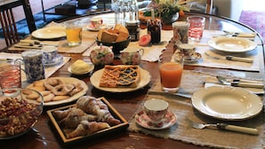 A dining table set with various breakfast items, including pastries, bread, and beverages. - Donna Etrusca B&B (Sutri)