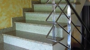 A staircase with a metal handrail and a yellow wall. - Hostal O Rancheiro (Vigo)