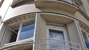 A multi-story building with a curved facade, large windows, and a grid-like pattern on the exterior. - Metropolis Prague Apartments (Prague)