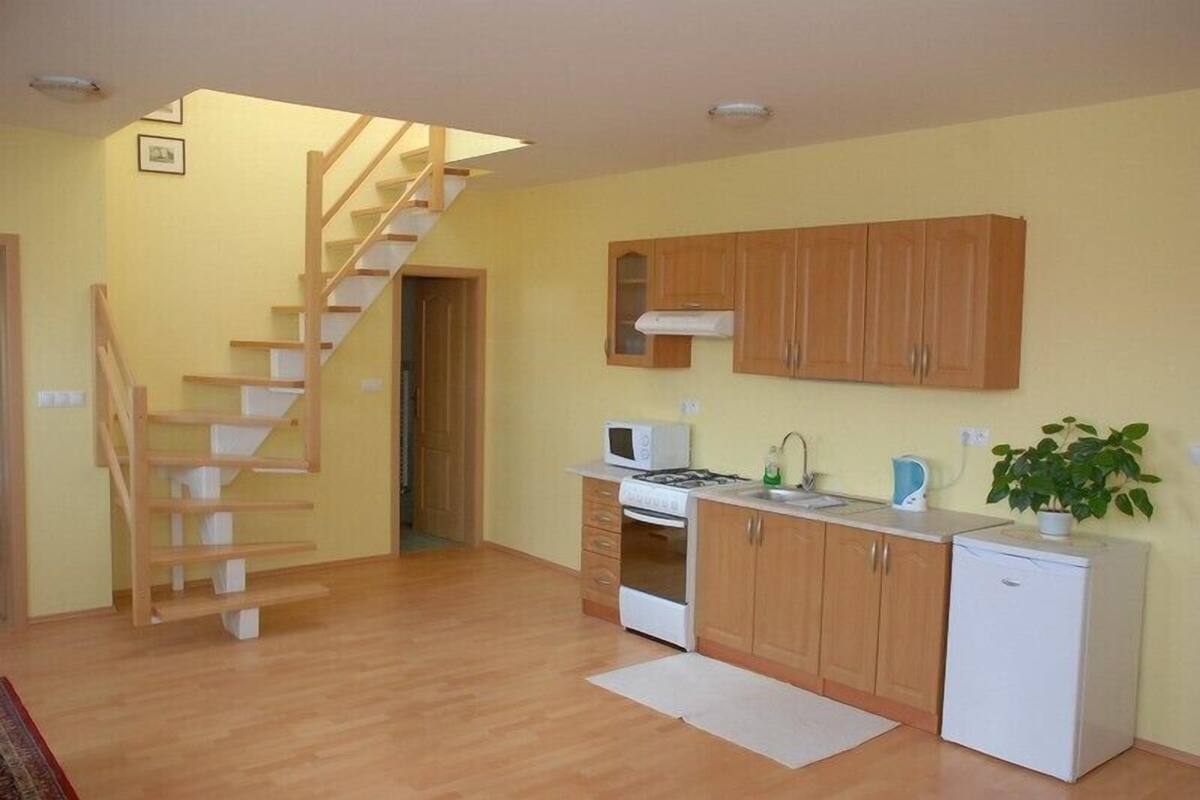 A kitchen with wooden cabinets, a microwave, a stove, and a refrigerator.