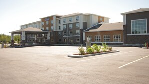 A multi-story hotel with a parking lot in front.