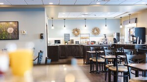A modern cafe with wooden furniture, a bar area, and decorative wall art.