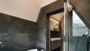 A modern bathroom with a bathtub, a shower, and a vanity with a mirror.