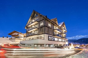 A multi-story hotel with a modern design, featuring balconies and large windows.