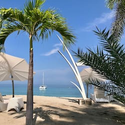 On the beach, white sand, sun loungers, beach umbrellas