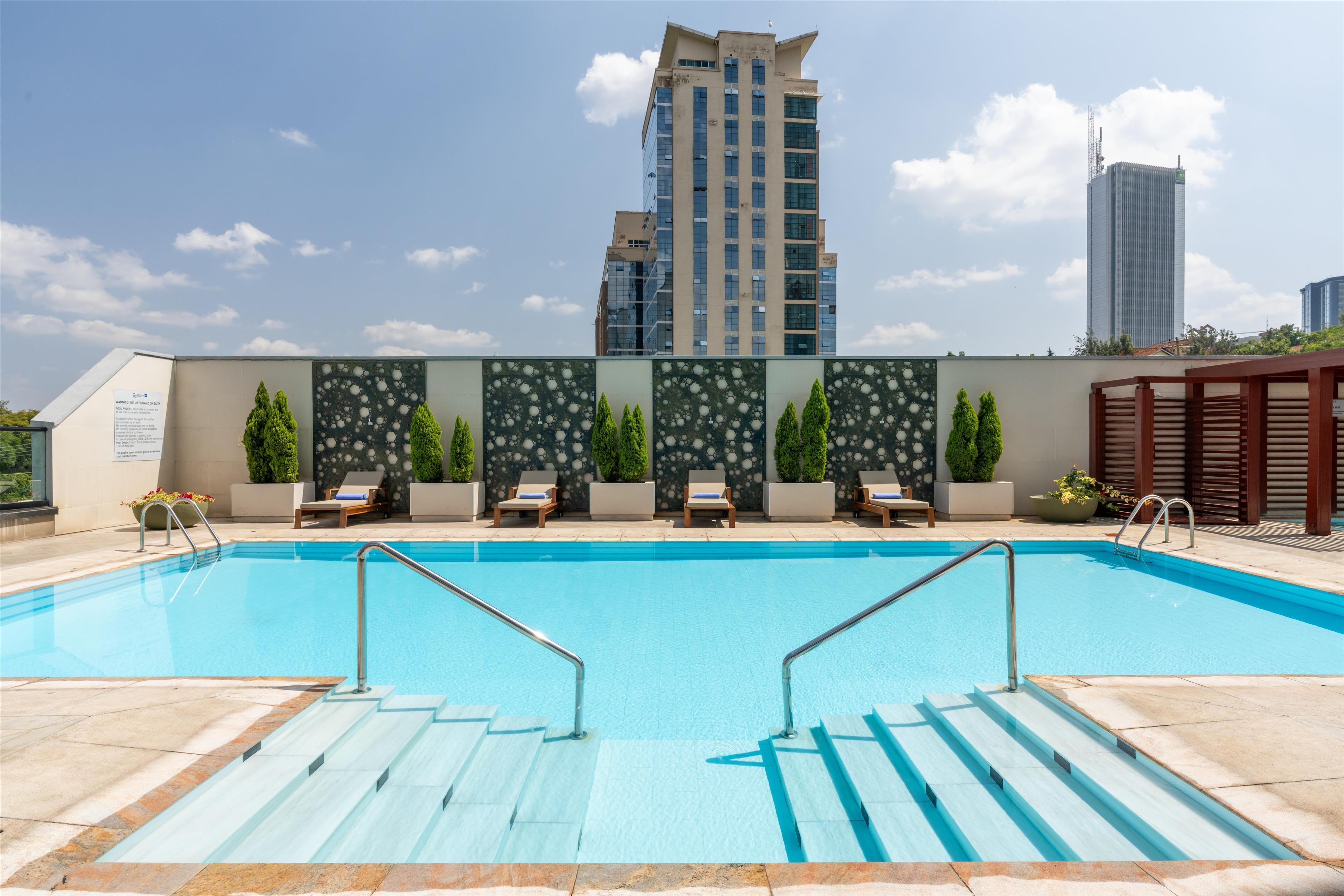 室外游泳池，池畔遮阳伞，日光浴躺椅