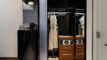 A modern bathroom with a black vanity, a glass shower enclosure, and a wooden cabinet with a built-in microwave.